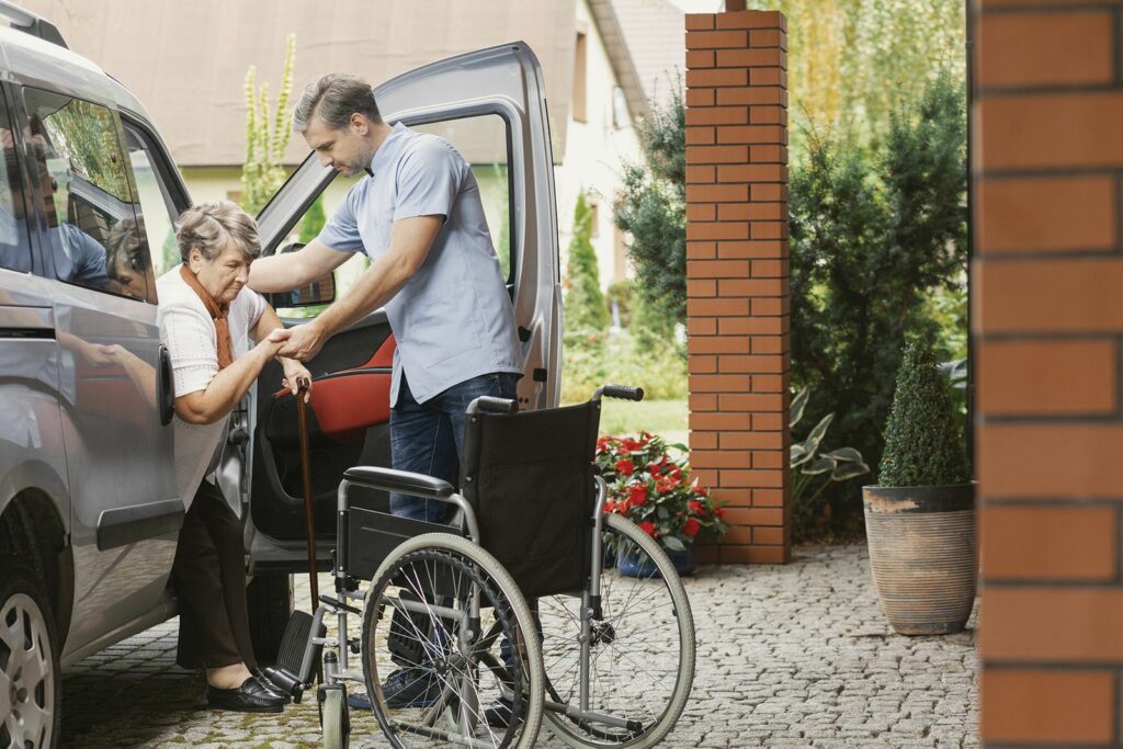 Senior Caregiver Transportation Assisting A Senior From Wheelchair to Car Safely In Weston, Southwest Ranches, Plantation, FL, Sunrise, FL