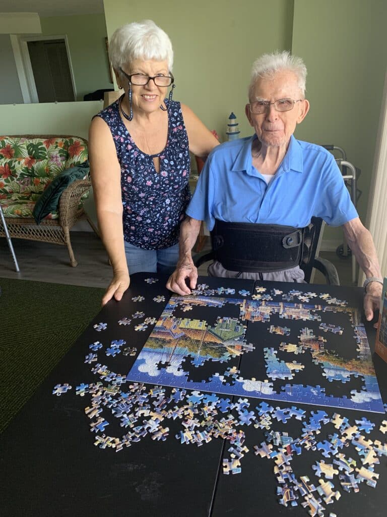 Seniors Helping Seniors caregiver assisting an older adult with a jigsaw puzzle at home in Clearwater