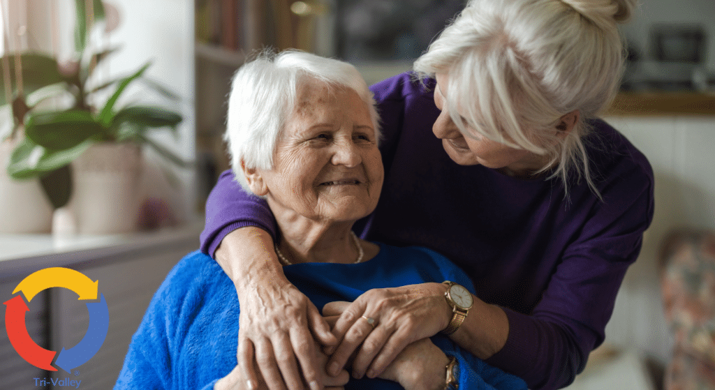 In-home caregiver embracing senior client during a compassionate care visit