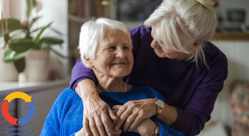 In-home caregiver embracing senior client during a compassionate care visit