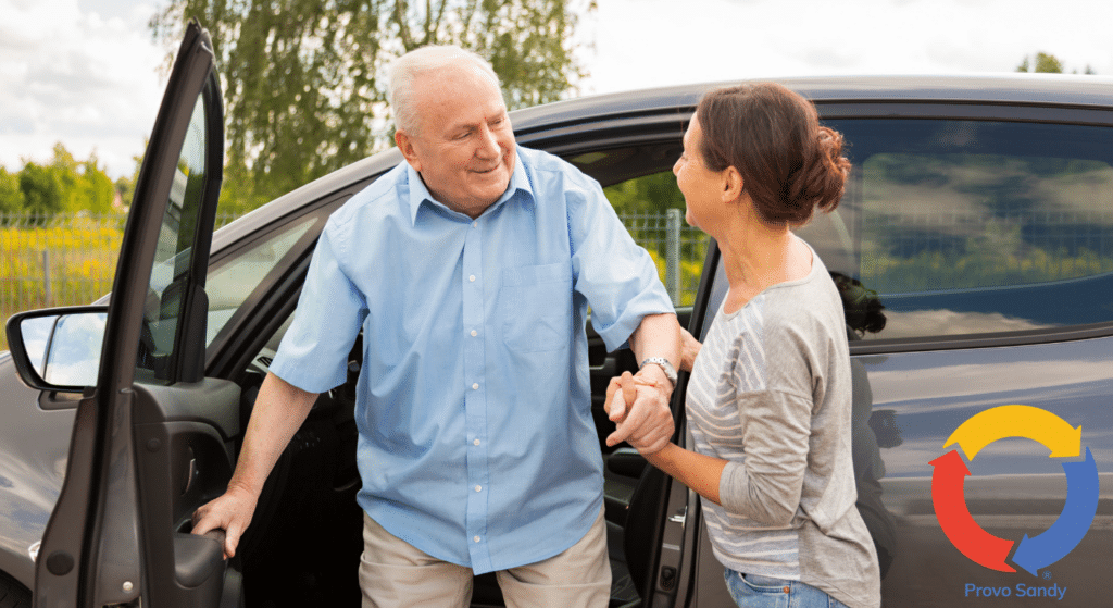Older man getting out of a car with assistance from a older woman.