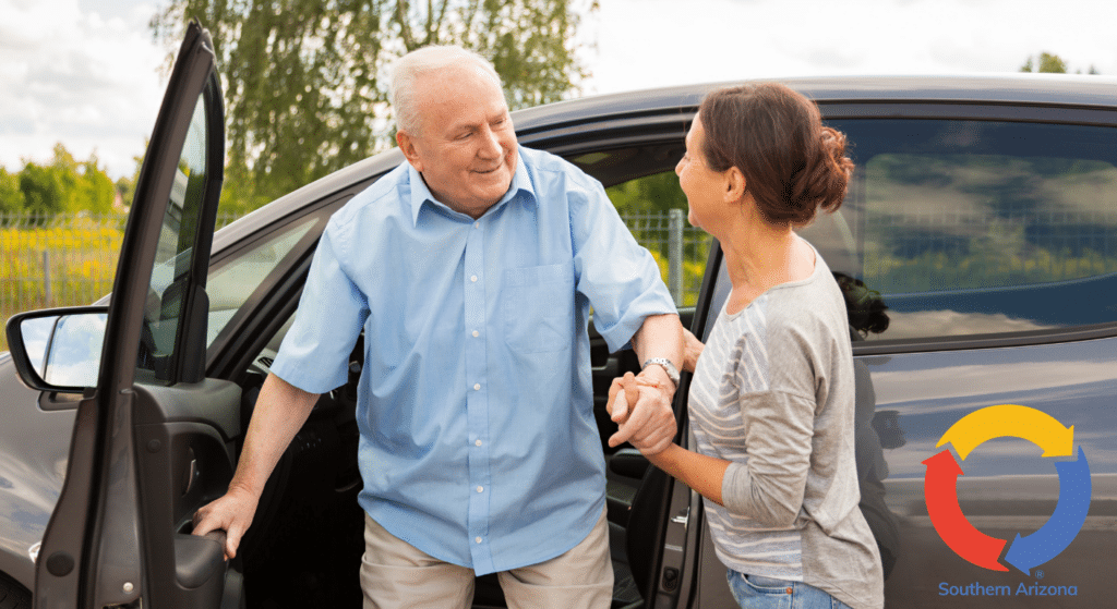 Older man getting out of a car with assistance from a older woman.